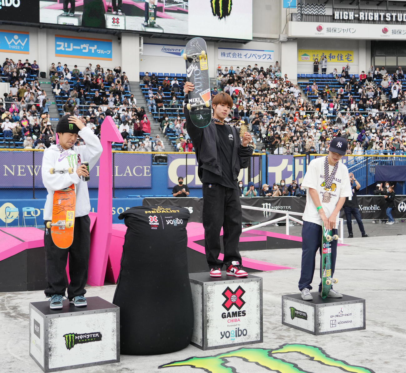 男子スケートボードストリートで優勝し、表彰台の上でメダルを手にする堀米。左は2位の池田、右は3位の白井（撮影・菅敏）