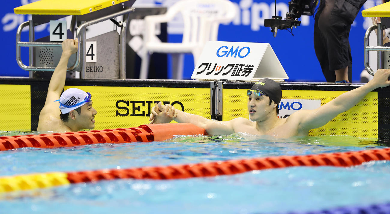 男子400メートル個人メドレー決勝、優勝した瀬戸（右）は本多と健闘をたたえ合う（撮影・垰建太）