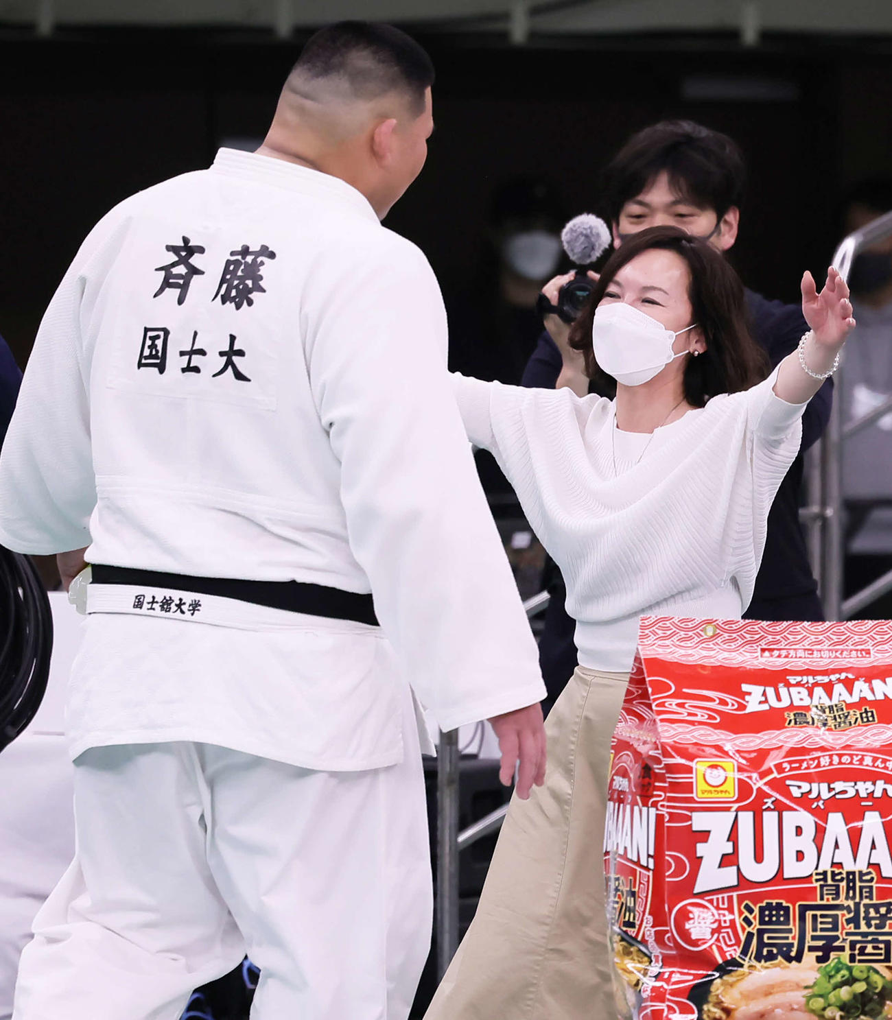 斉藤（左）と抱き合い優勝を喜ぶ母三恵子さん（中央）（撮影・足立雅史）