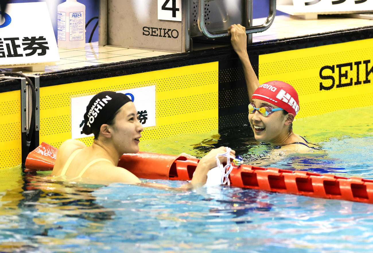 女子200メートル個人メドレーで優勝した大橋（左）と笑顔で握手を交わす2位成田（撮影・足立雅史）
