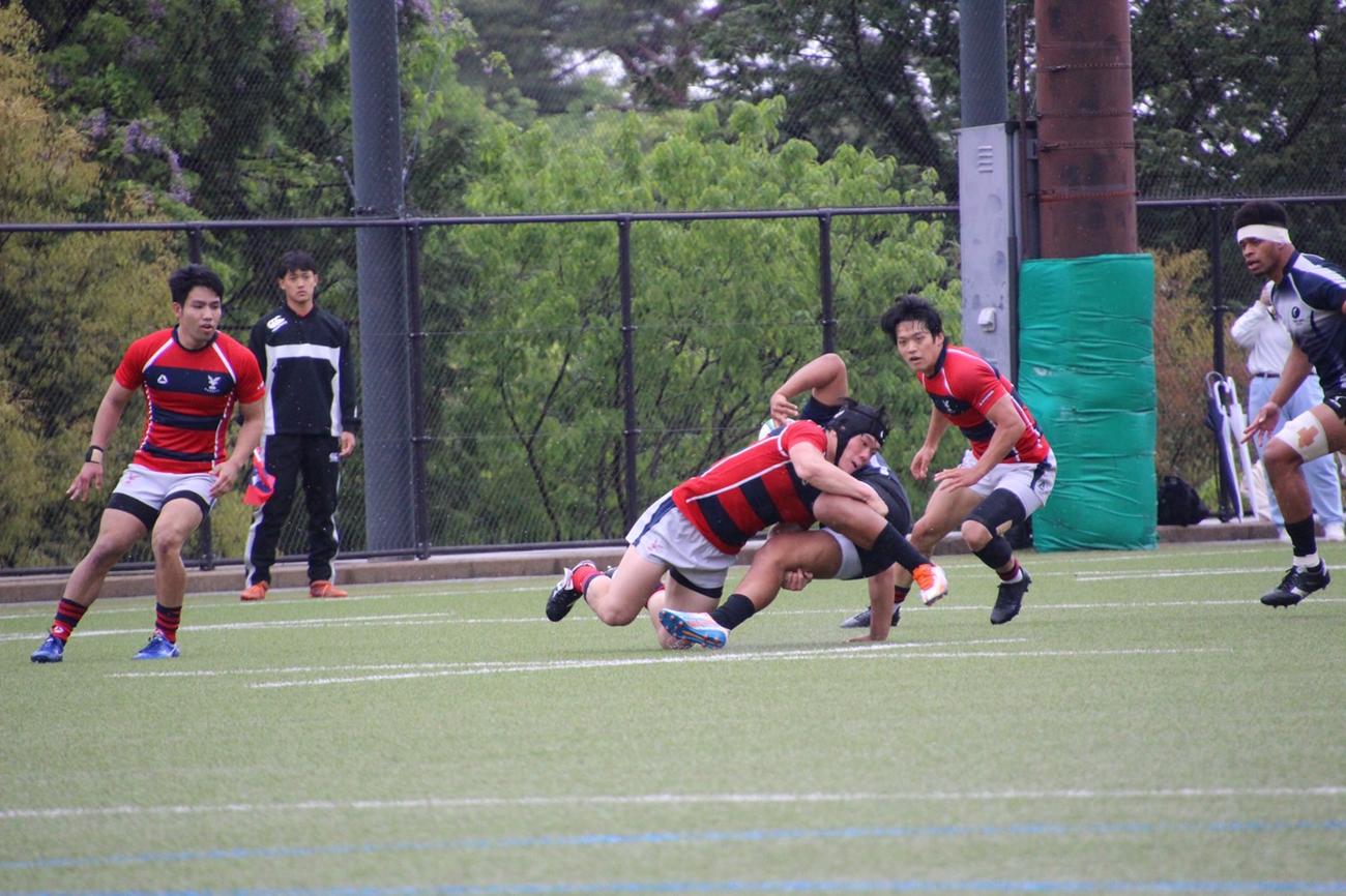 天理大との試合でひたむきにタックルに入る京産大の選手（京産大提供）