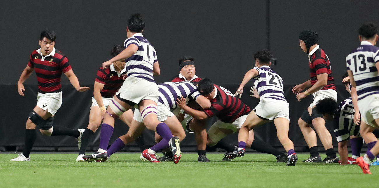 早大対明大　明大の猛攻をタックルで防ぐ早大・平山（中央右）（撮影・佐藤翔太）