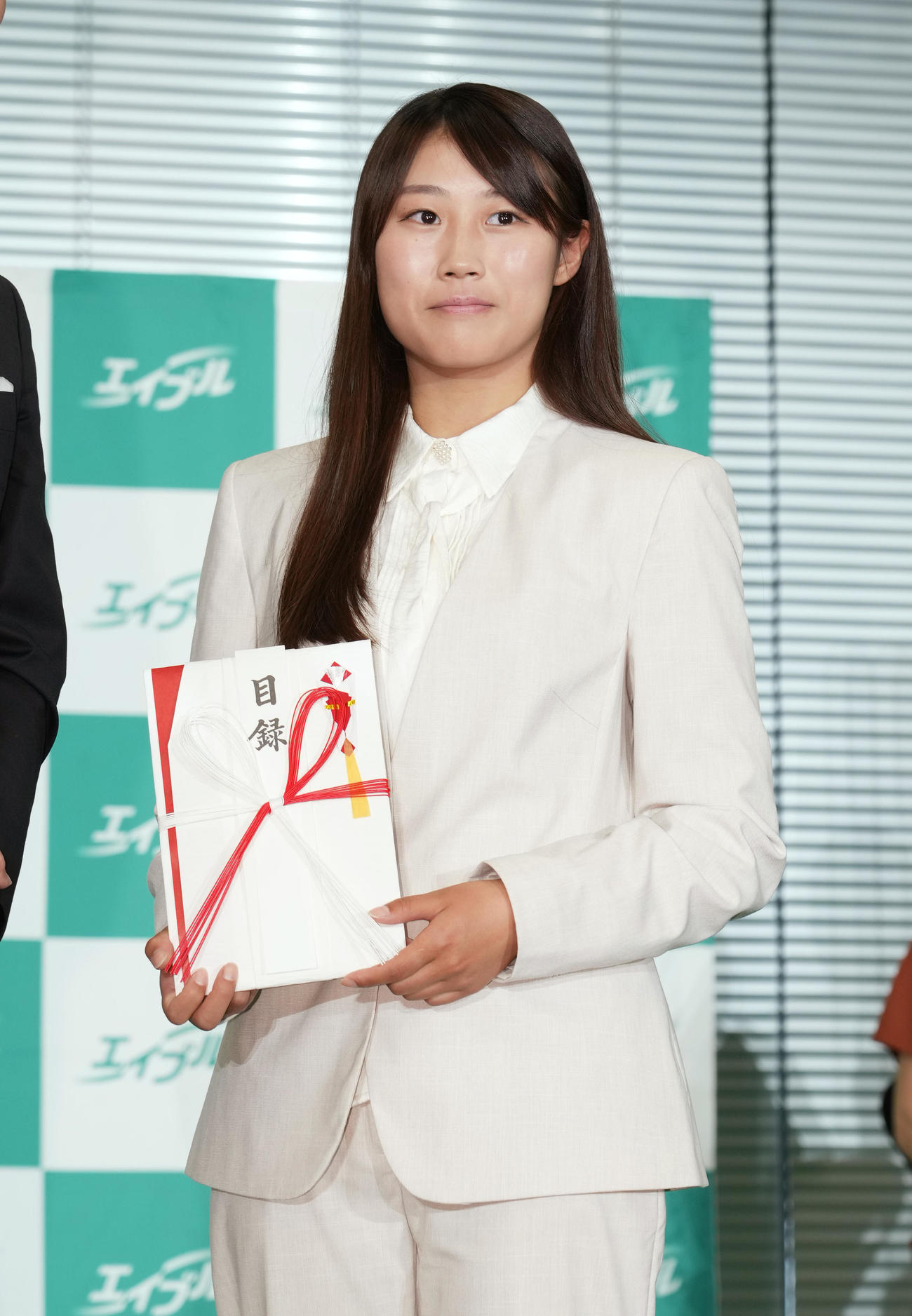 式典に参加し、目録を手に記念写真に納まる村瀬（撮影・菅敏）
