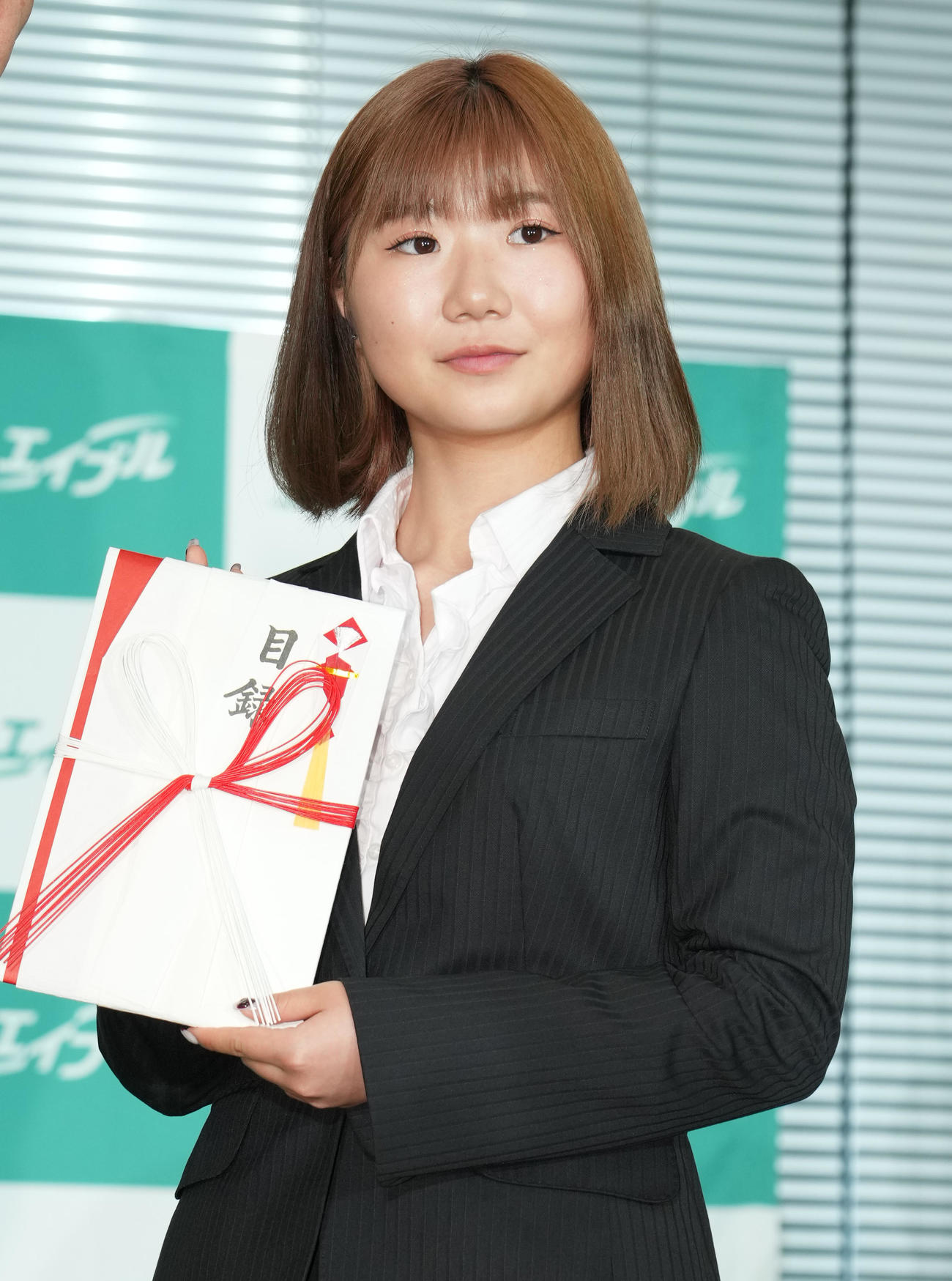 式典に参加し、目録を手に記念写真に納まる岩渕（撮影・菅敏）