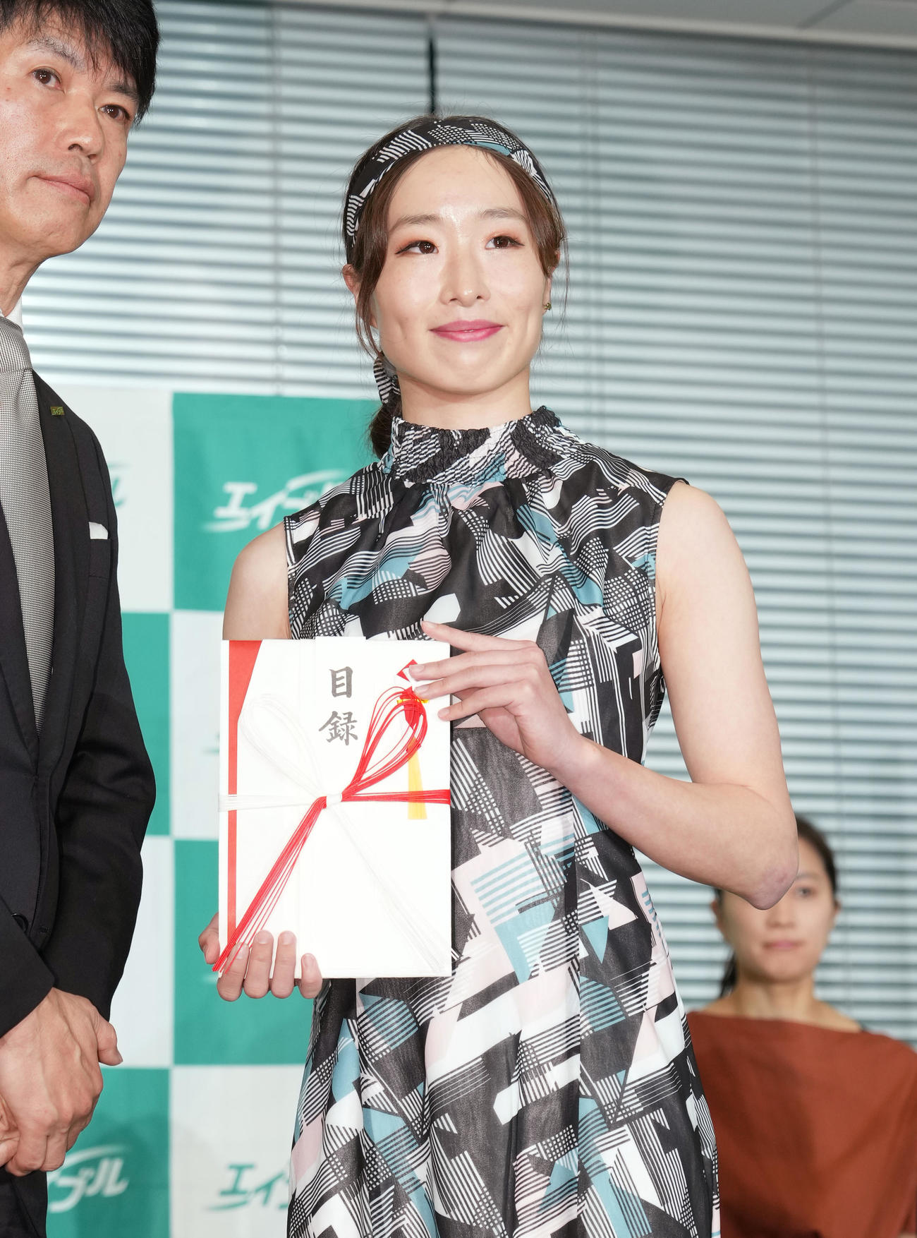 式典に参加し、目録を手に記念写真に納まる鬼塚（撮影・菅敏）