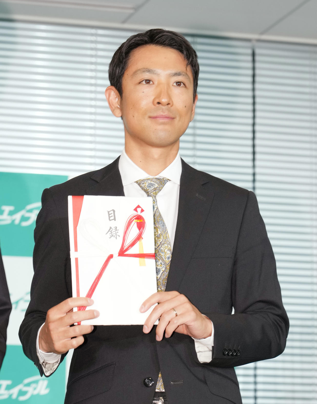 式典に参加し、目録を手に記念写真に納まる渡部（撮影・菅敏）