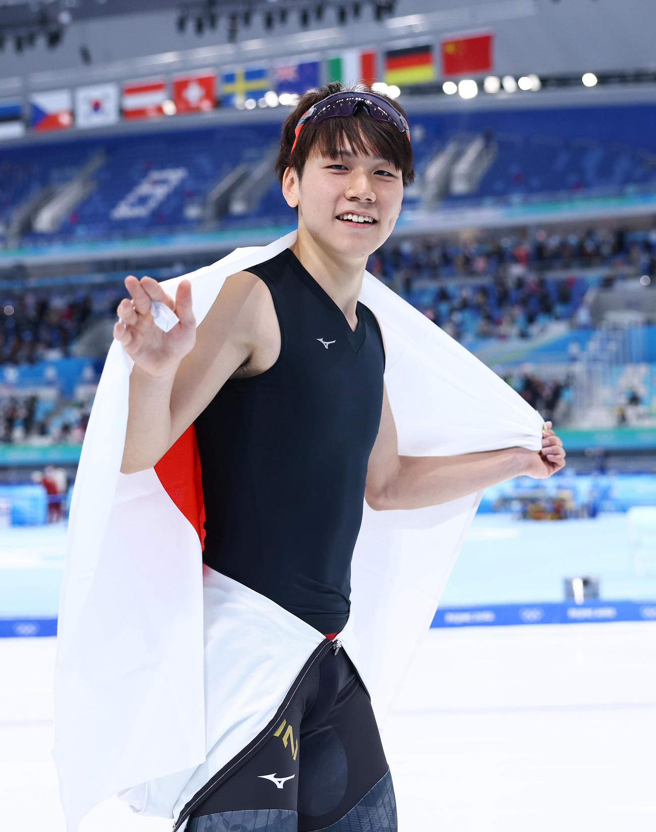 北京五輪スピードスケート男子500メートルで銅メダルに輝き、笑顔で日の丸を掲げる森重（2022年2月12日撮影）