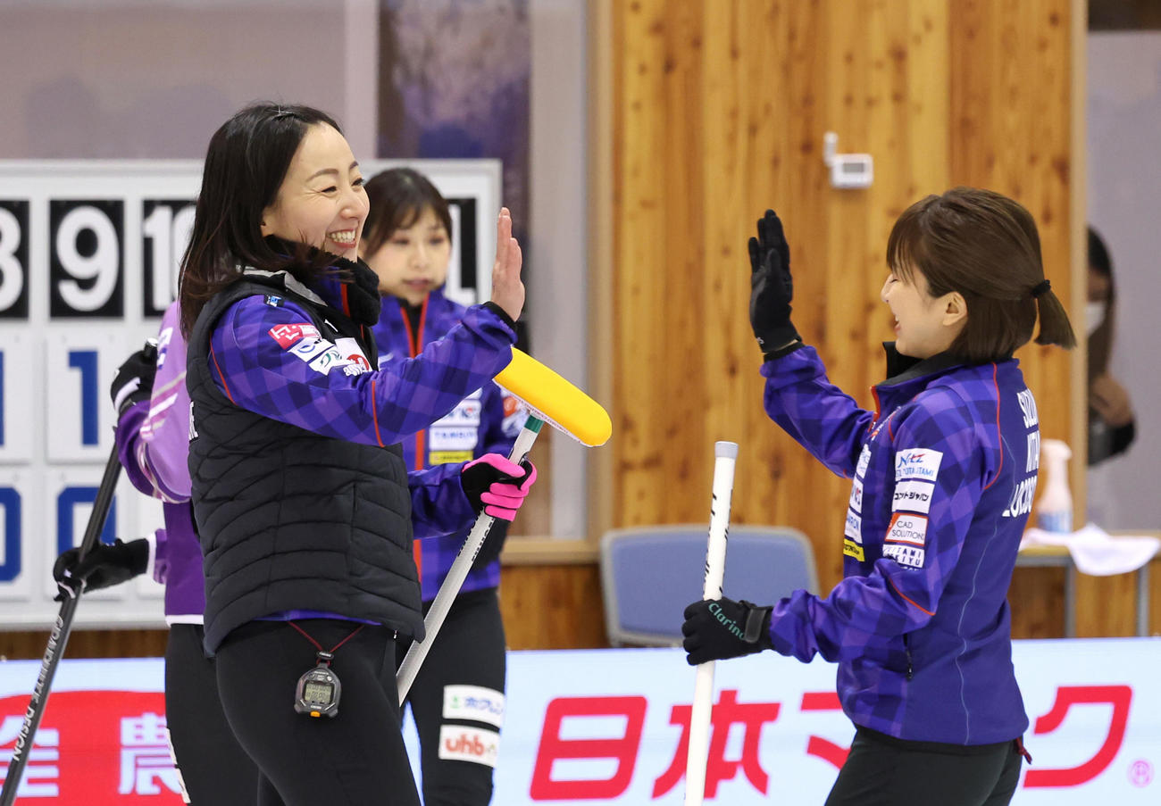 北海道銀行を下して決勝進出を決め、笑顔でハイタッチをかわすロコ・ソラーレのスキップ藤沢（左）と鈴木（代表撮影）
