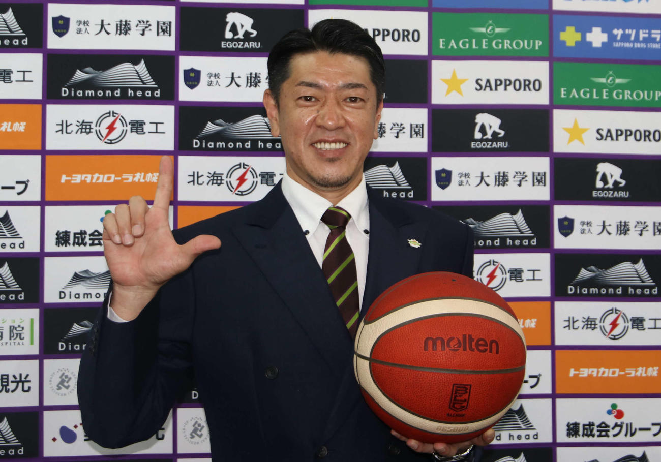 会見後、レバンガポーズをとり笑顔を見せるレバンガ北海道の佐古監督（撮影・山崎純一）