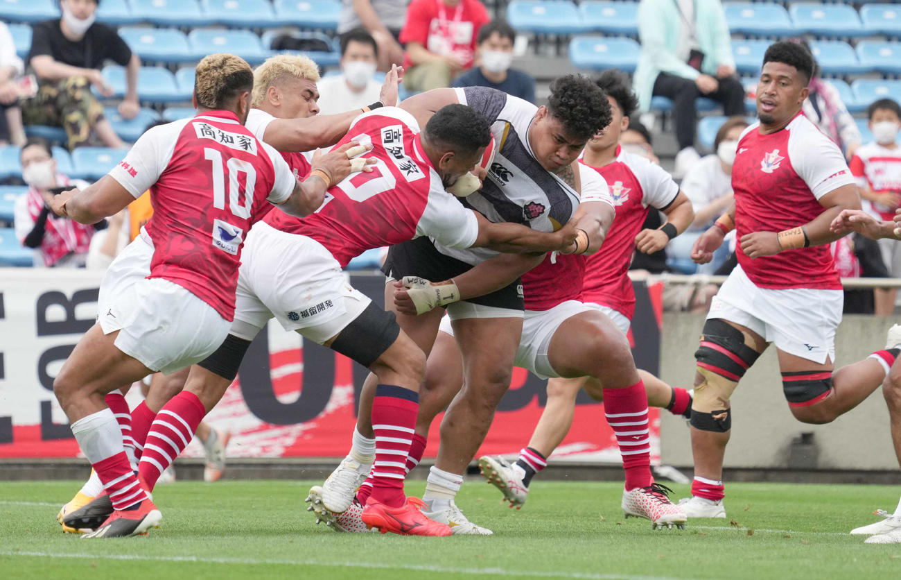 後半、エマージング・ブロッサムズNO．8タタフ（中央）はタックルを受けながらもトライを決める（撮影・小沢裕）