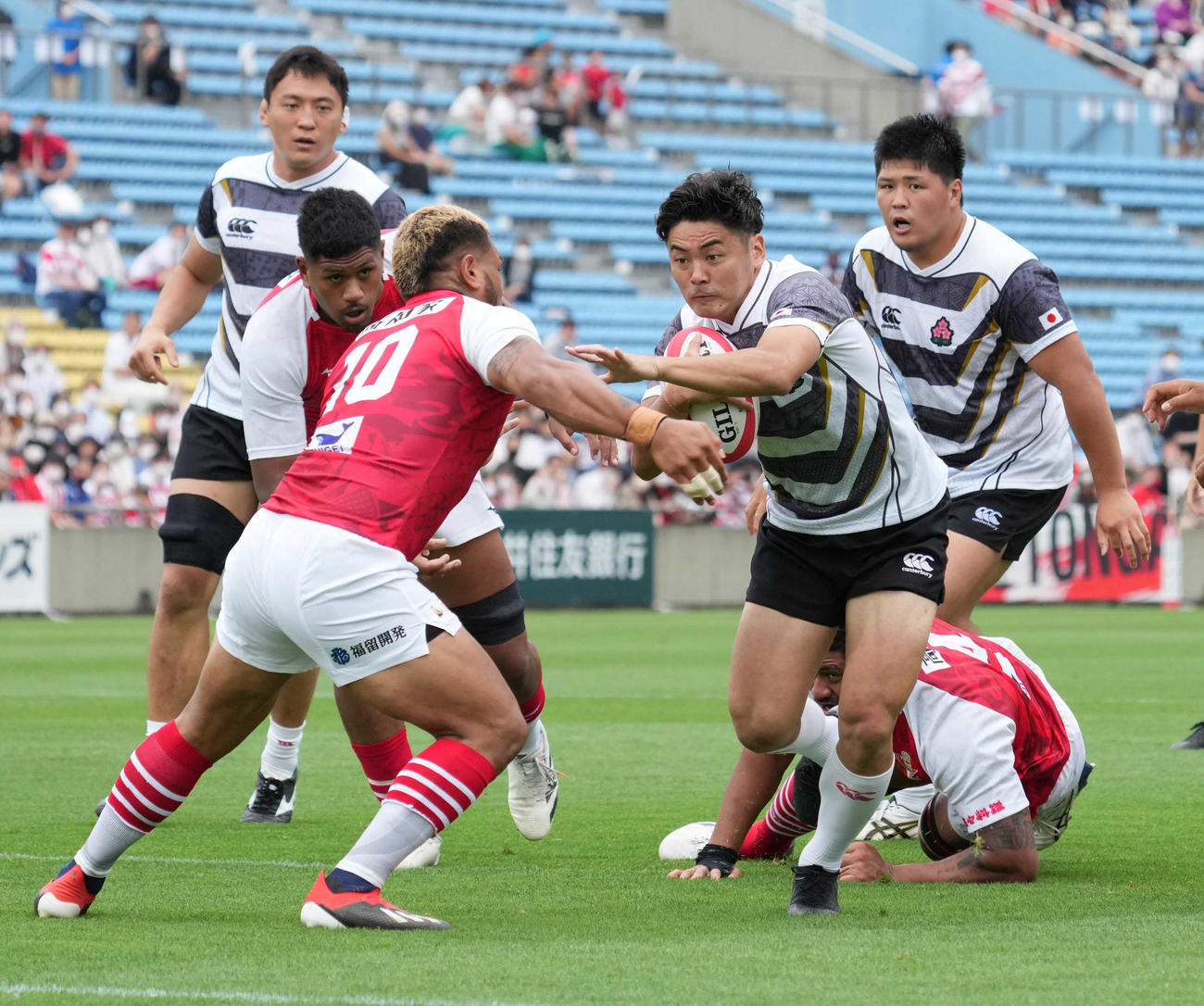 後半、エマージング・ブロッサムズWTB竹山（右）はトライを狙うもトンガ・サムライフィフティーンSOレメキに阻まれる。左奥は辻（撮影・小沢裕）