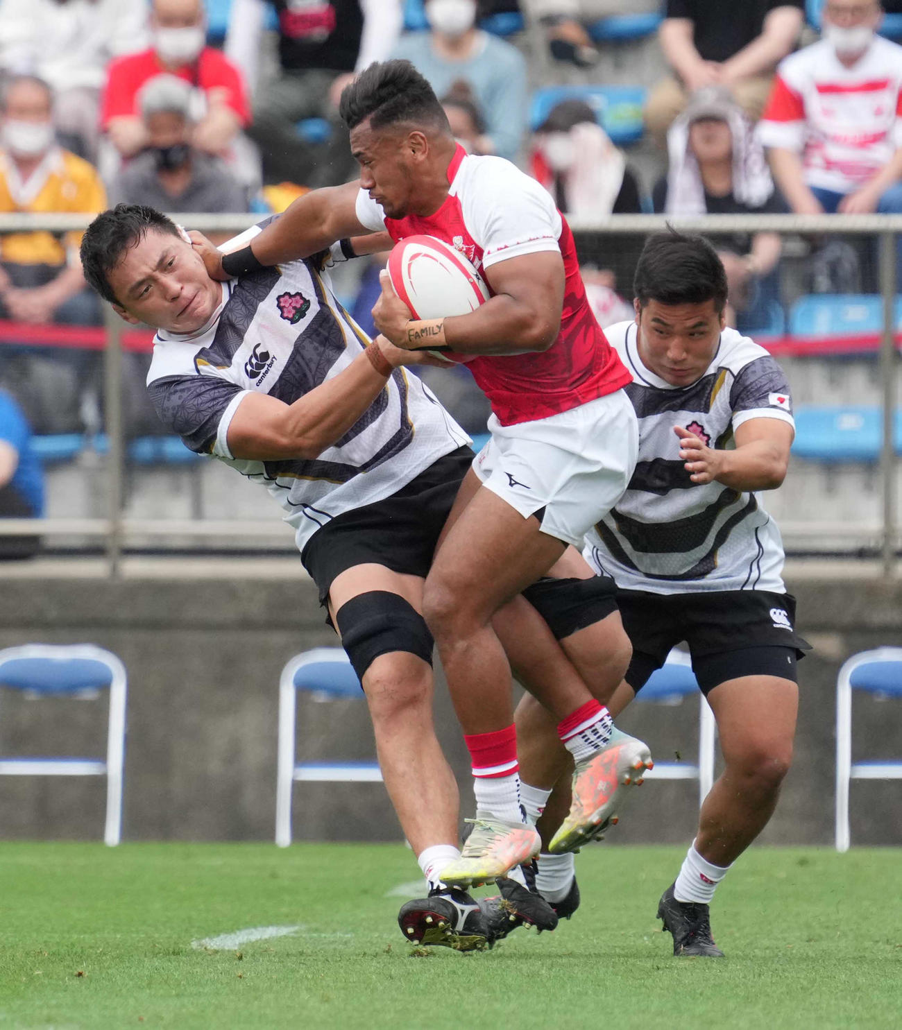 後半、トンガ・サムライフィフティーンのマノア（中央）にタックルするエマージング・ブロッサムズFW辻（左）（撮影・小沢裕）