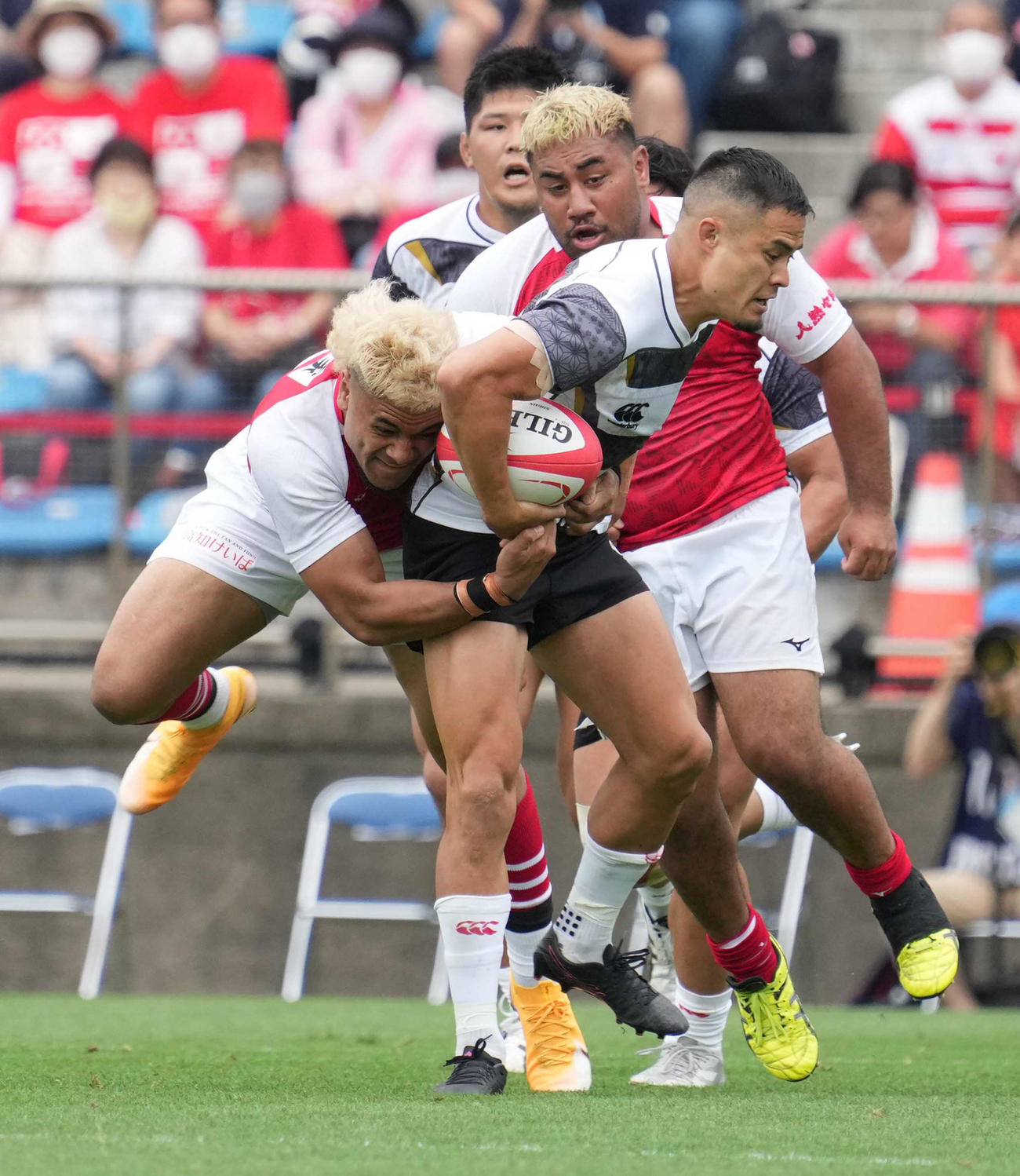 タックルを受けながら突進するSO田村優（2022年6月11日撮影）