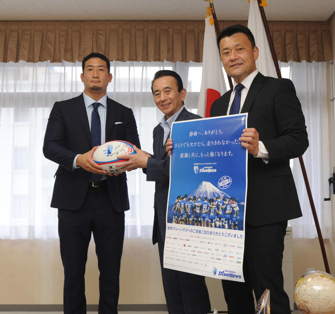鈴木浜松市長（中央）と写真に納まる静岡ブルーレヴズの山谷社長（右）と松本