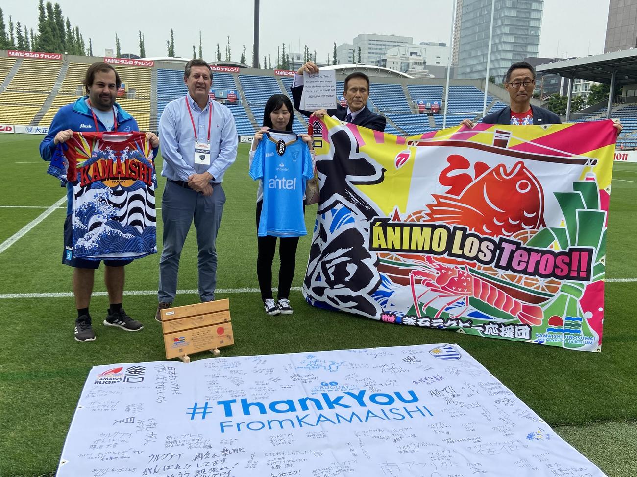 テストマッチ前日練習後にウルグアイ協会のサンティアゴ・スリンガル会長（左から2人目）に大漁旗などを手渡した釜石ラグビー応援団の関係者（撮影・松本航）