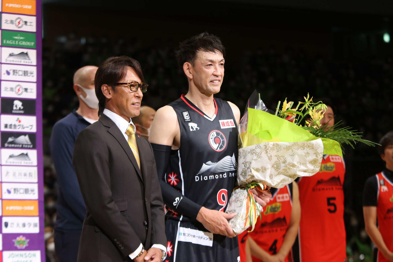 チームレジェンド対チームナイン　スキージャンプのレジェンド葛西（左）から花束を受け取るレバンガ北海道の折茂氏（撮影・山崎純一）