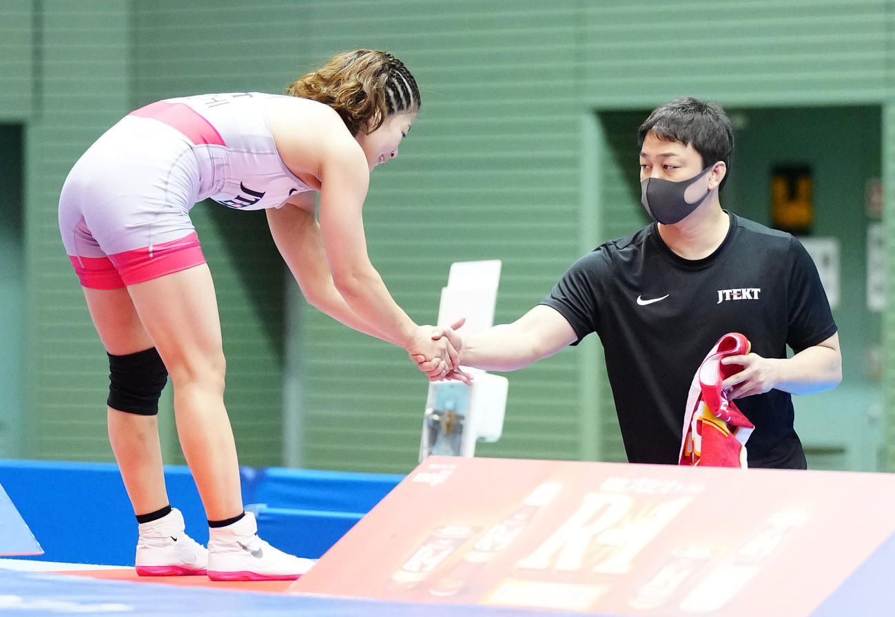 女子フリースタイル55キロ級で優勝し、夫でコーチの翔大氏（右）と握手を交わす志土地（撮影・江口和貴）