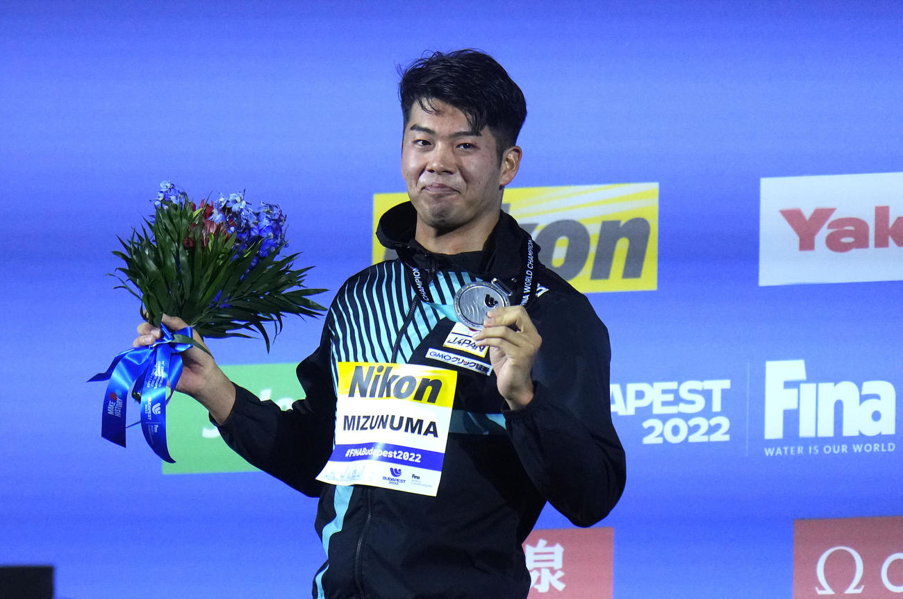 男子100メートルバタフライで銀メダルとなり、表彰式でメダルを掲げる水沼尚輝（AP）