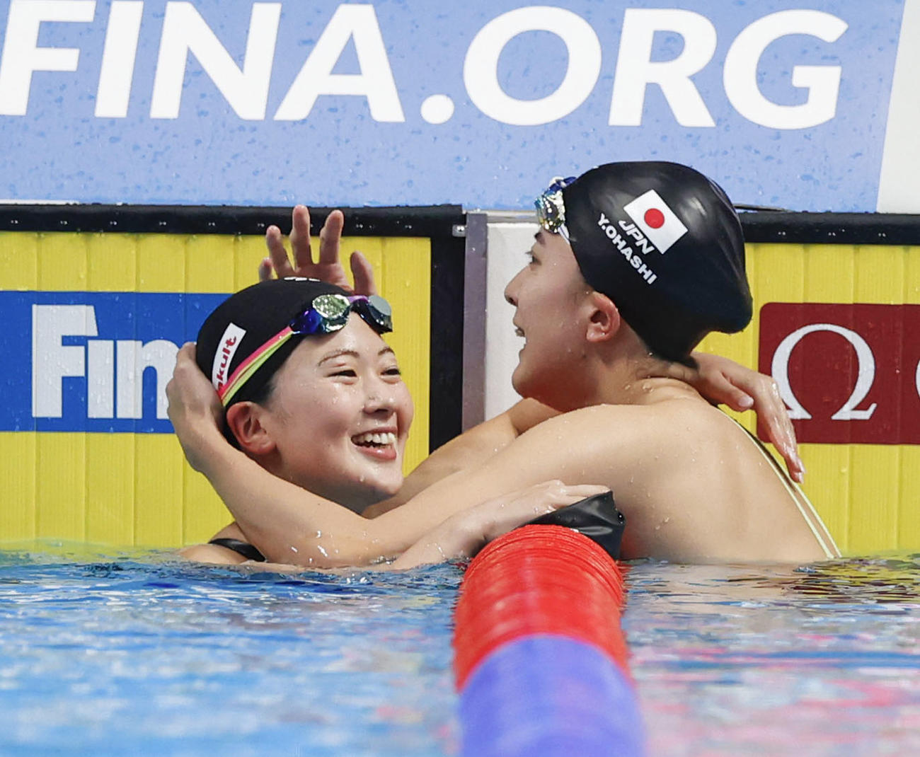 女子400メートル個人メドレー決勝のレースを終え、健闘をたたえ合う8位の谷川亜華葉（左）と5位の大橋悠依（共同）