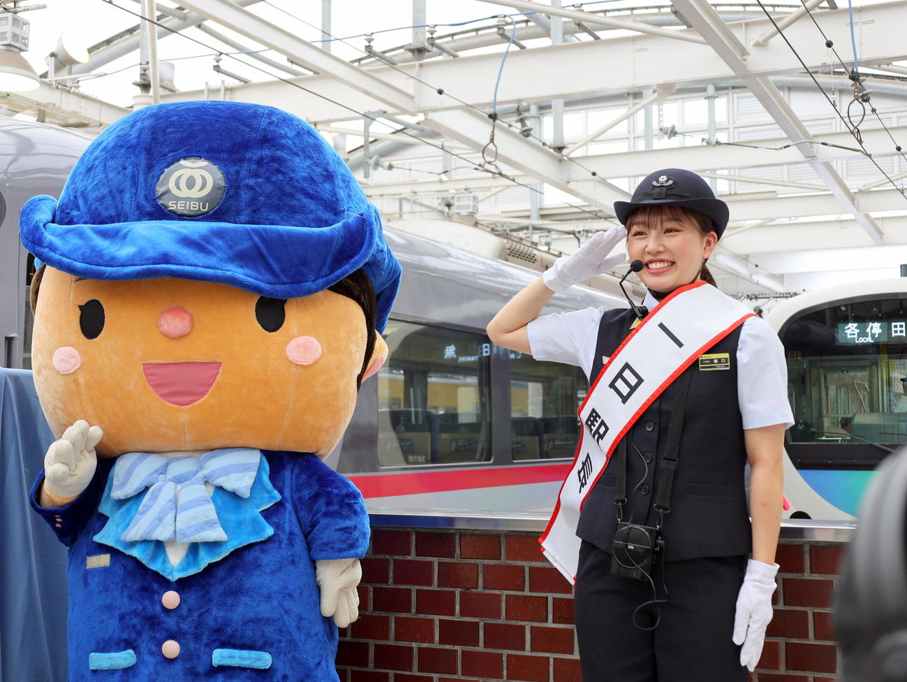 西武新宿駅の一日駅長を委嘱され、西武鉄道マスコットキャラクターのスマイルちゃんと敬礼ポーズを決めるフィギュアスケート女子の樋口新葉
