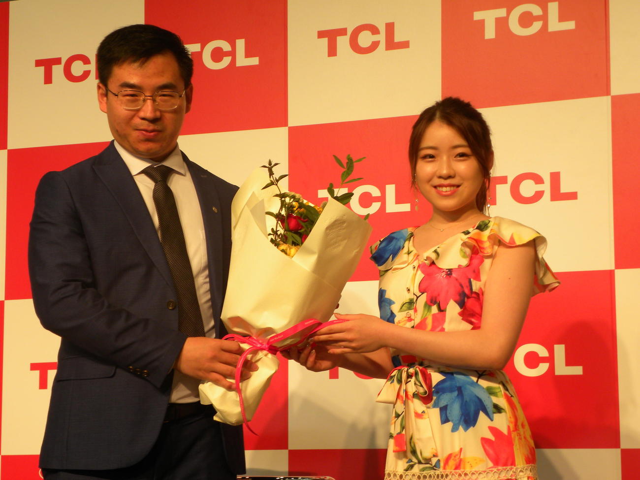 TCLテレビ新製品体験イベントで張社長から花束を受け取るアンバサダーの紀平梨花（右）（撮影・松本航）