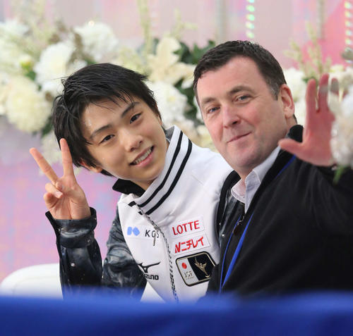2012年11月23日NHK杯　男子SPで世界歴代最高を更新する95・32点で首位となり、笑顔でVサインを決める羽生。右はオーサー・コーチ