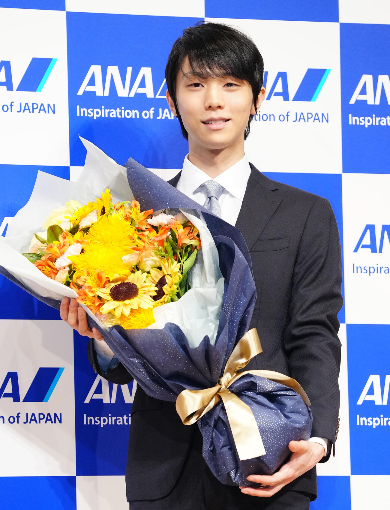 記者会見を終え、花束を手に写真に納まる羽生（撮影・江口和貴）