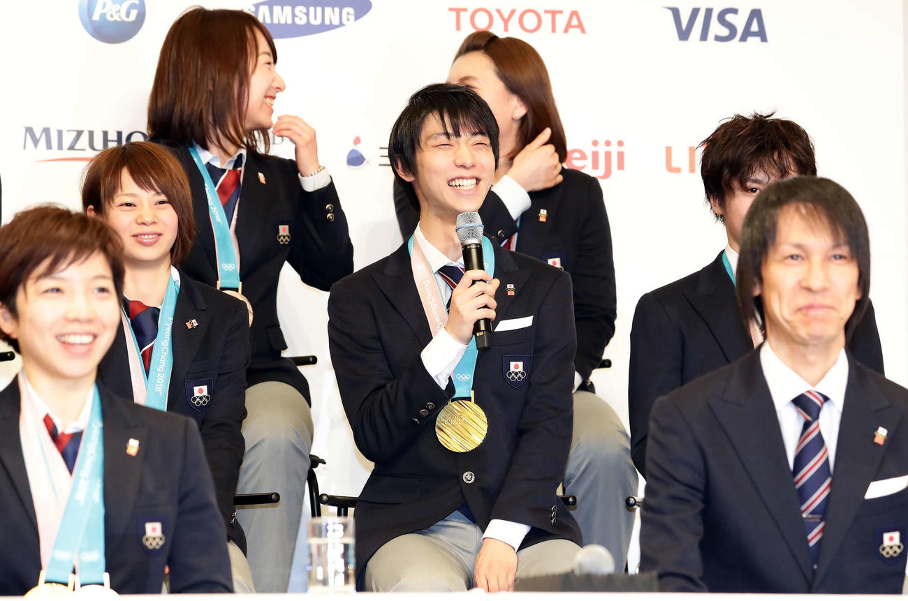 平昌五輪帰国会見で、次の五輪での主将の質問に最後は笑顔で答える羽生（中央）。右手前は葛西（2018年2月26日撮影）