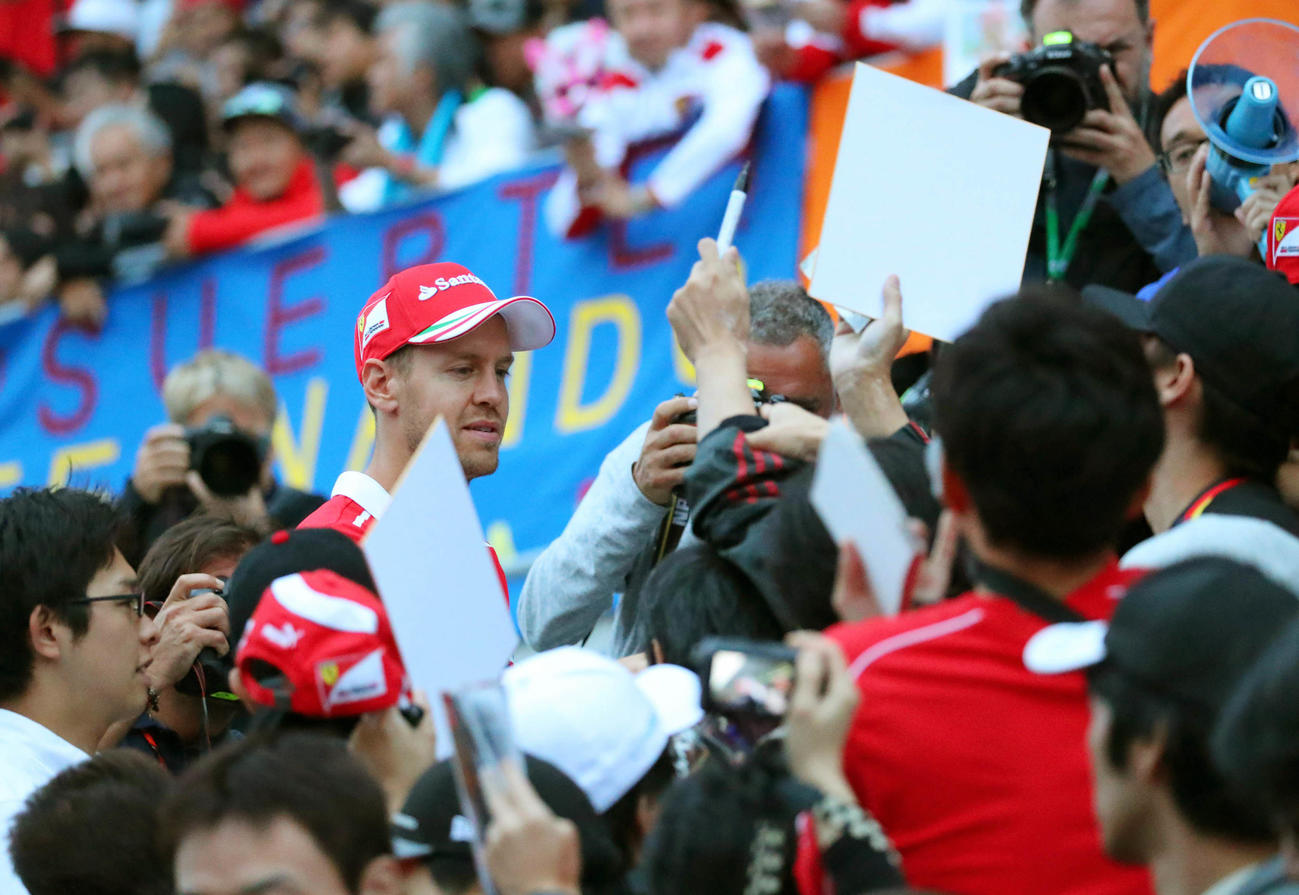 F1世界選手権第16戦日本GP　グランドスタンドに侵入してサイン入りカードを配布したセバスチャン・ベッテルは、ファンの熱烈な歓迎を受ける（2017年10月撮影）