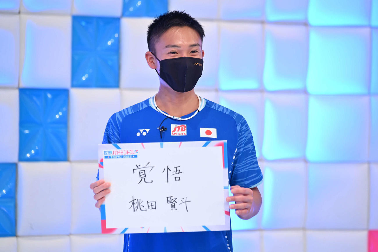 バドミントンの世界選手権を前に、「覚悟」と書いたフリップを持つ桃田（テレビ朝日提供）