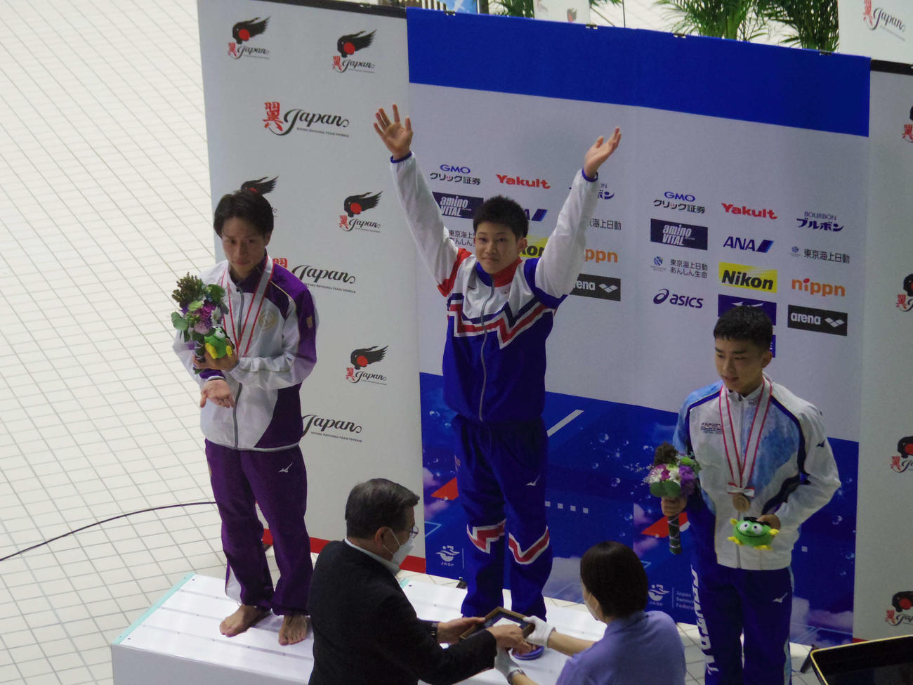 日本選手権4連覇を果たし、表彰式で両手を広げる飛び込み男子の玉井
