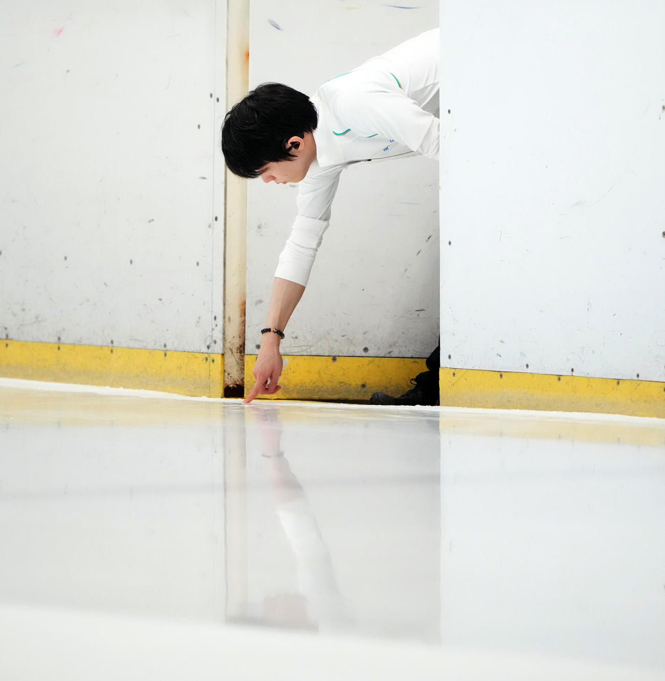 練習公開前、リンクの感触を指で確かめる羽生結弦さん（撮影・江口和貴）