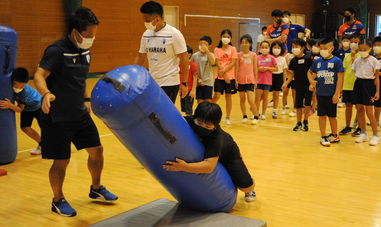ラグビーのタックルを練習する児童たち