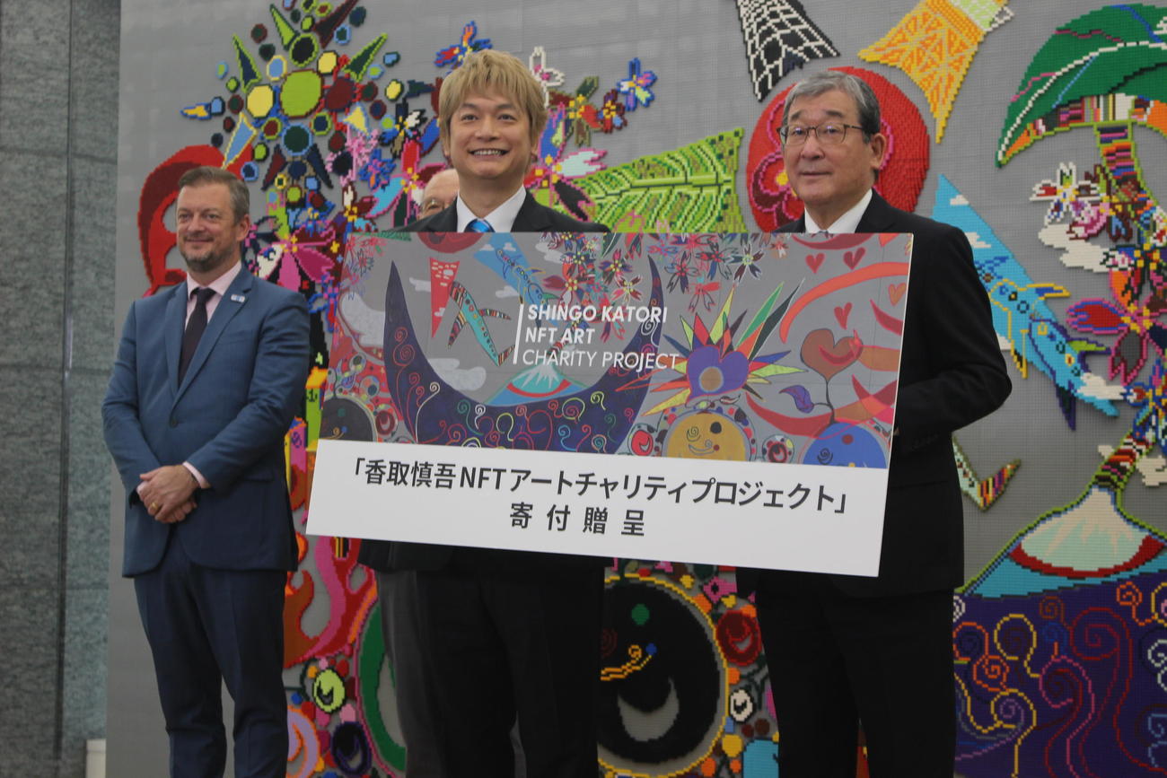日本財団パラスポーツサポートセンターの山脇会長（右）に寄付を贈呈した香取慎吾。左は国際パラリンピック委員会のパーソンズ会長（撮影・首藤正徳）