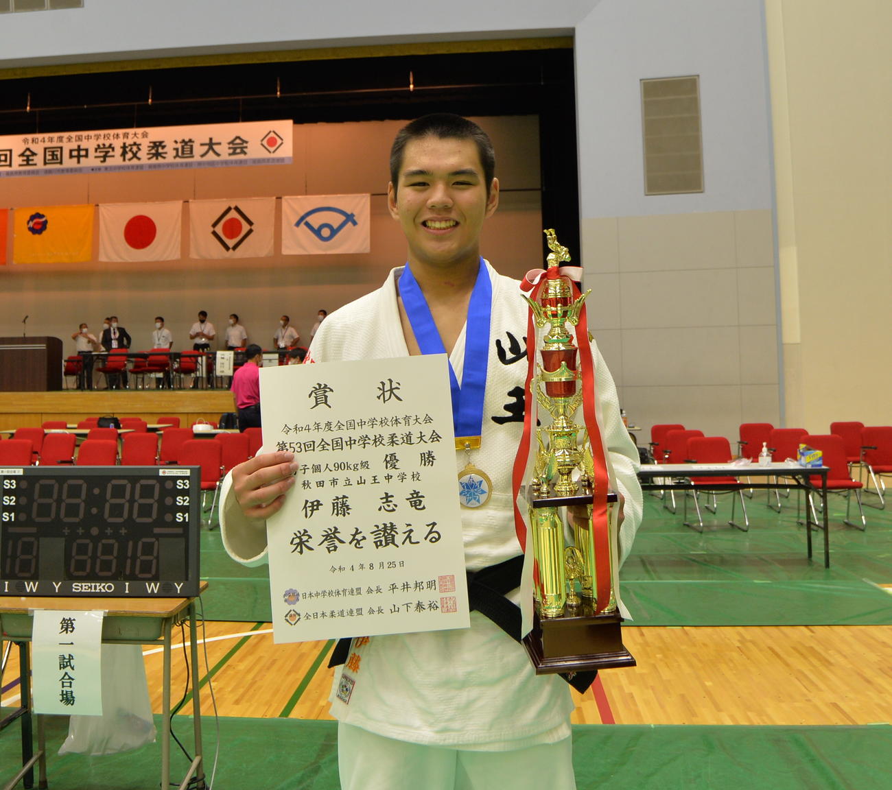 男子90キロ級で優勝した伊藤は、トロフィーを手に笑顔を見せる