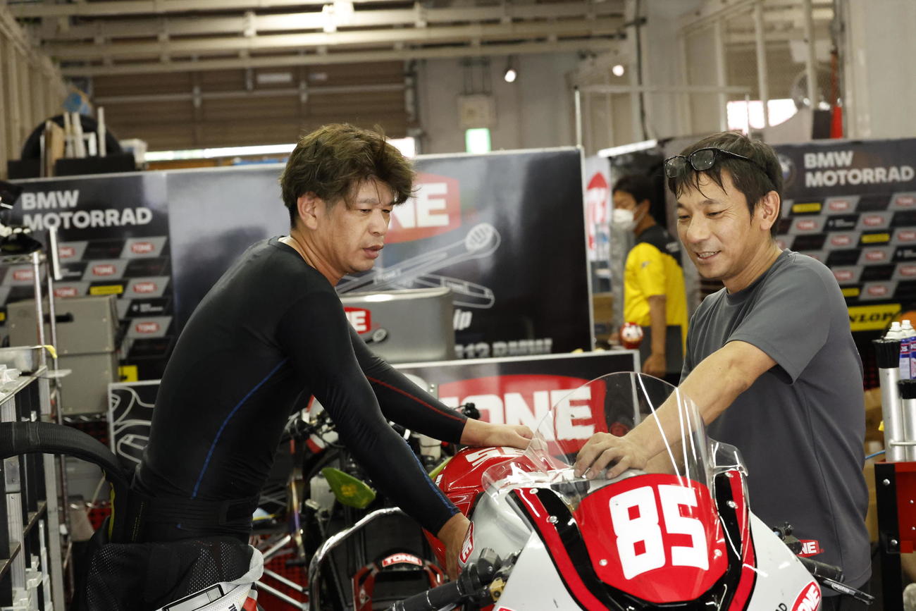 8月の鈴鹿8時間耐久ロードレースで仲間と話す高村嘉寿（右）（TONE RT SYNCEDGE4413 BMW提供）