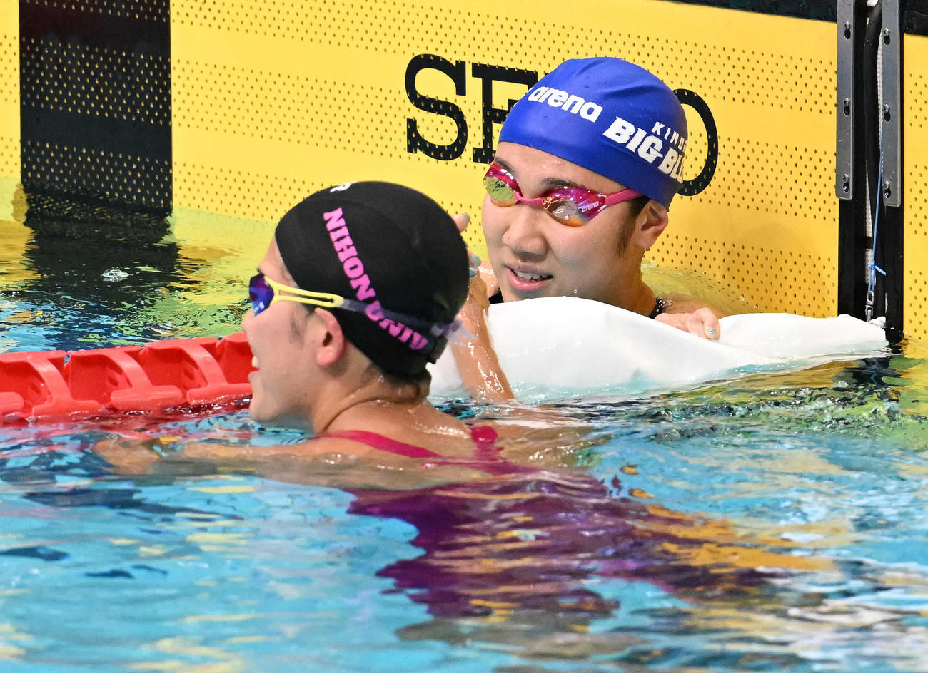 女子800メートル自由形で優勝した難波（奥）は小堀と握手を交わす（撮影・滝沢徹郎）