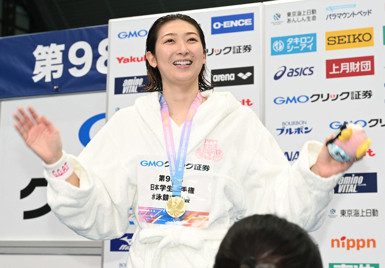 女子100メートル自由形表彰式で優勝した池江は観客席に手を振る（撮影・滝沢徹郎）