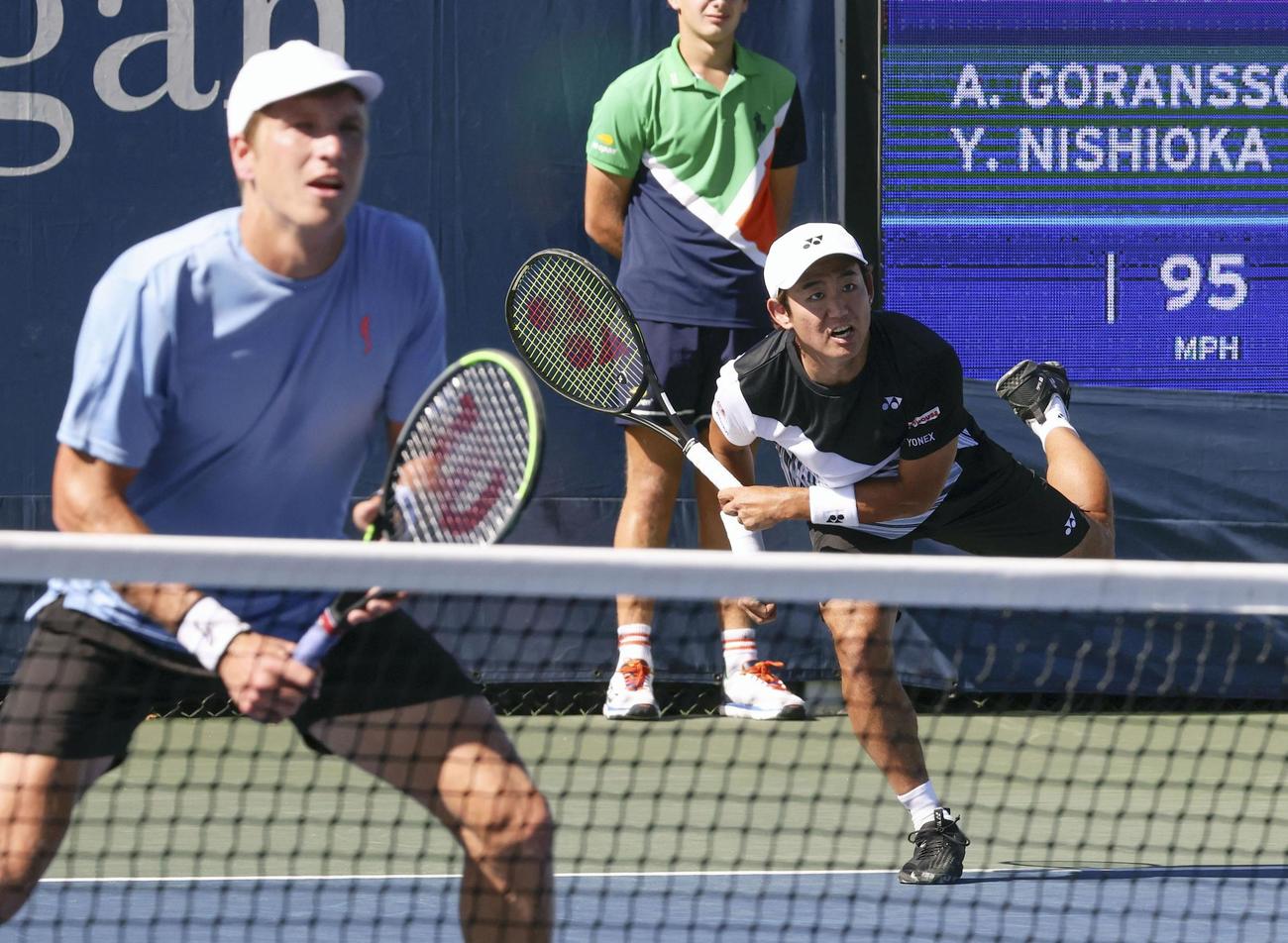 男子ダブルス1回戦でプレーする西岡良仁（右）、アンドレ・ヨランソン組（共同）