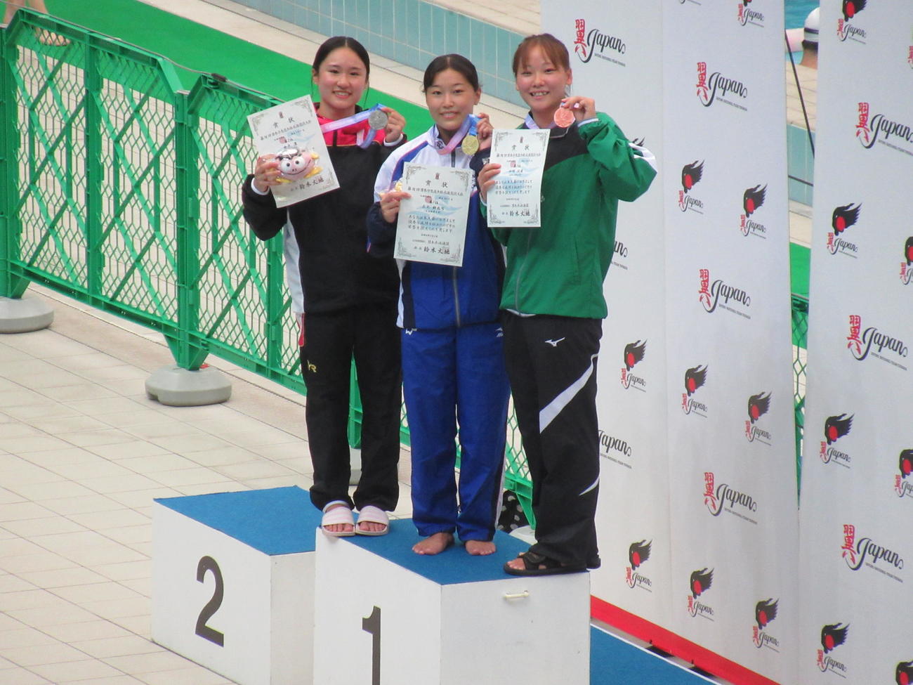 女子板飛び込み表彰式。中央は三上紗也可、左は2位金戸凜、右は3位山崎佳蓮（撮影・益田一弘）
