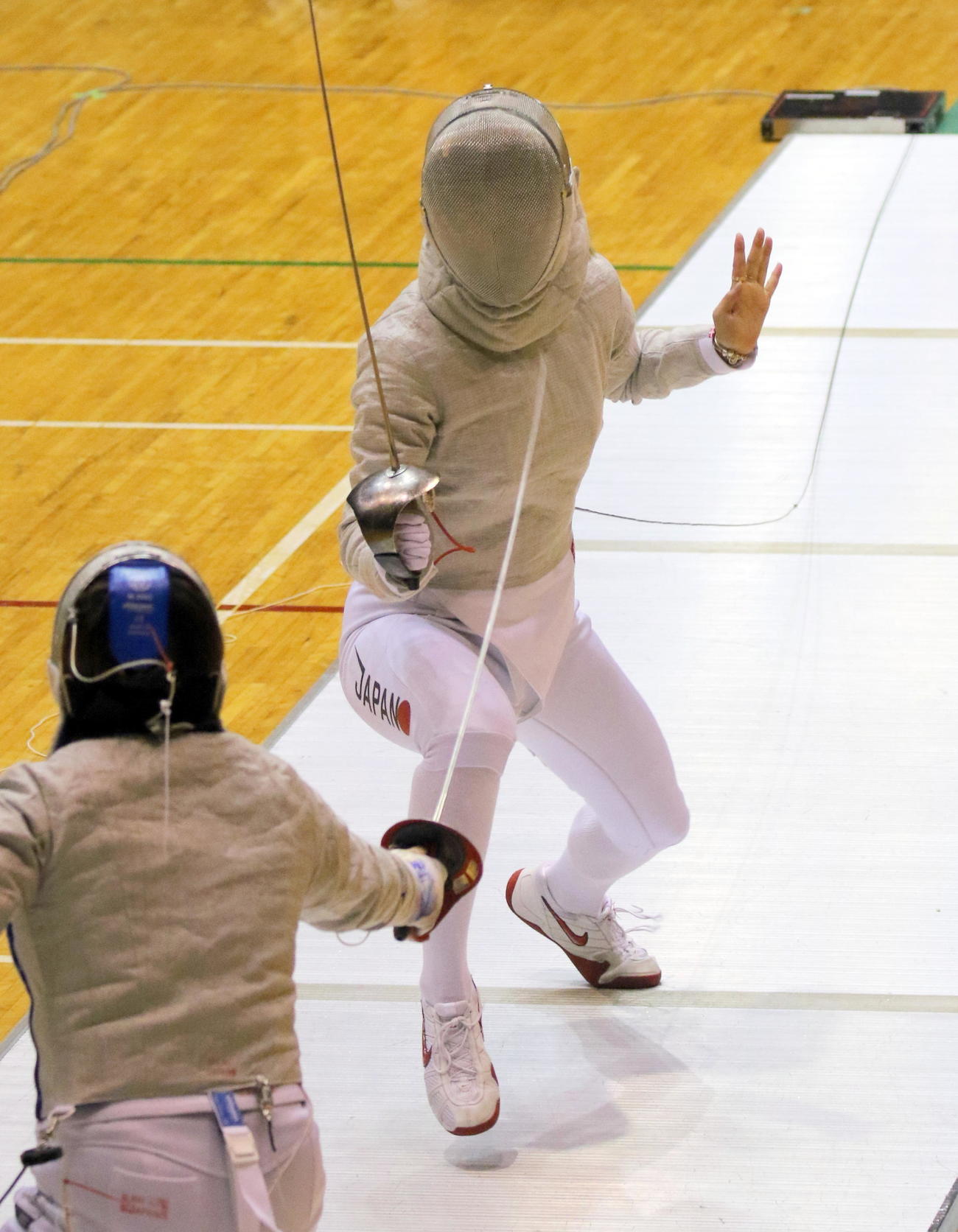 フェンシング全日本選手権　女子サーブル準々決勝で日本代表のチームメート小林かなえ（背中）を攻める世界女王の江村美咲