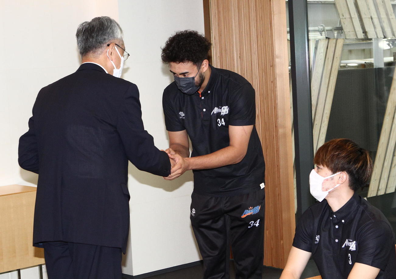 磯田長岡市長（左）と握手を交わす遠藤（中央）