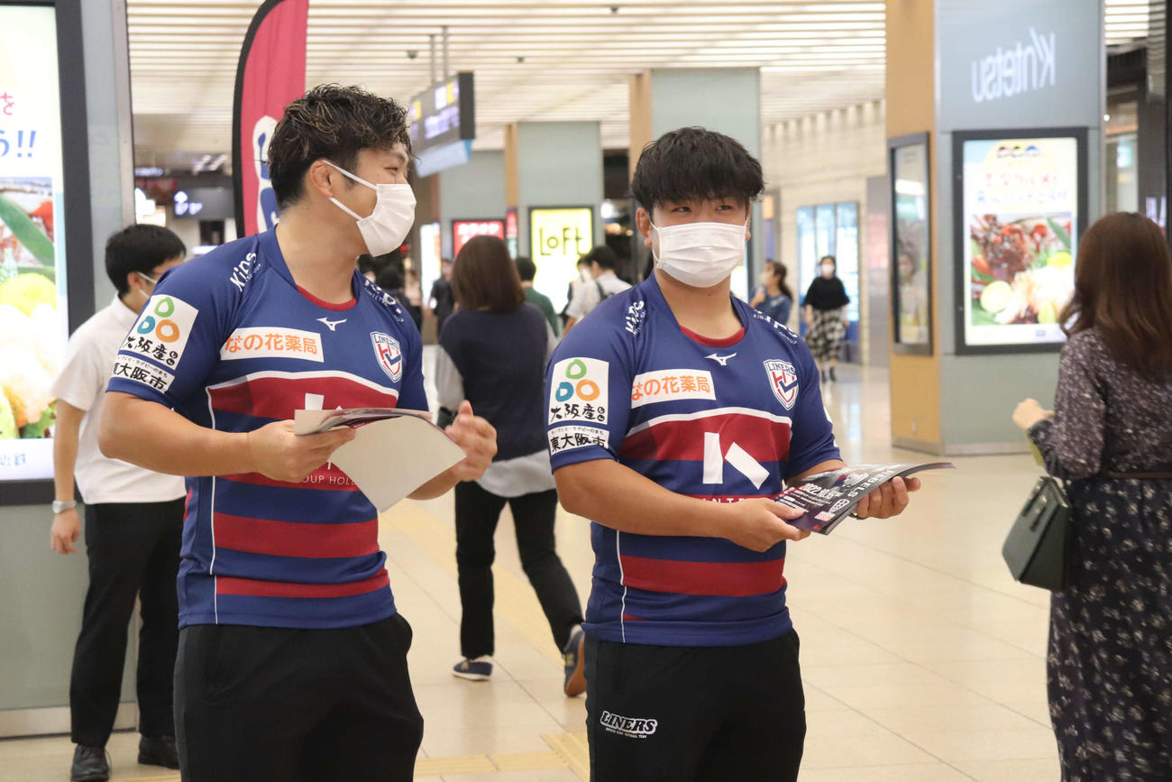 国際親善試合に向けたチラシ配りを行う花園近鉄ライナーズの横井隼（左）と上山黎哉（撮影・波部俊之介）