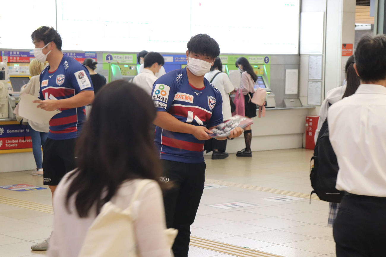 国際親善試合に向けたチラシを配る花園近鉄ライナーズの横井隼（左）と上山黎哉（撮影・波部俊之介）
