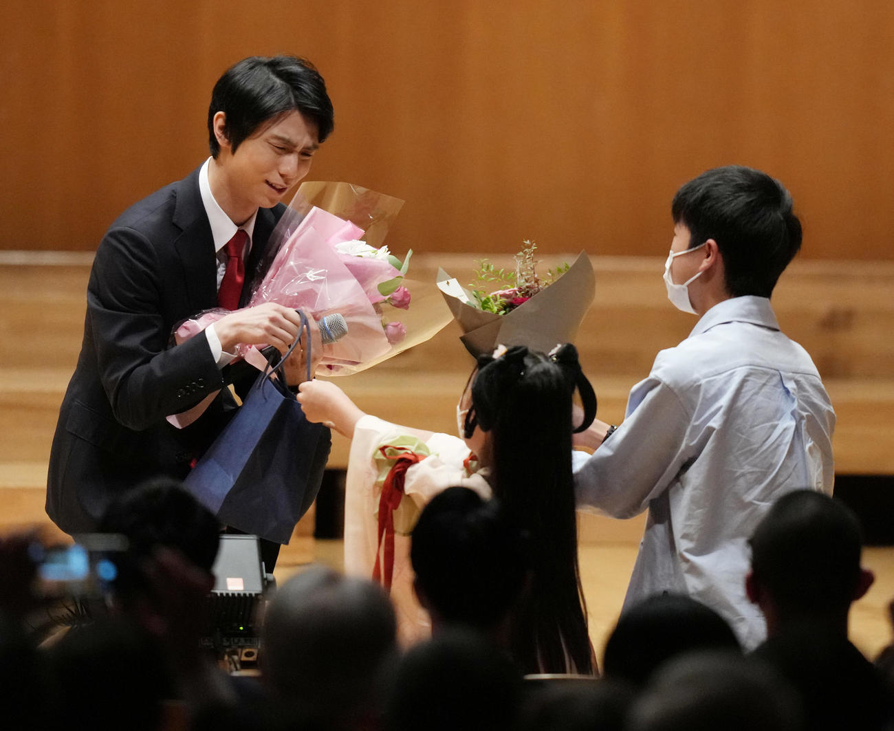 日中国交正常化50周年記念慶典の記念撮影に臨んだ羽生結弦さん（左）は会場に詰め掛けたファンから花束贈呈を受ける（撮影・小沢裕）