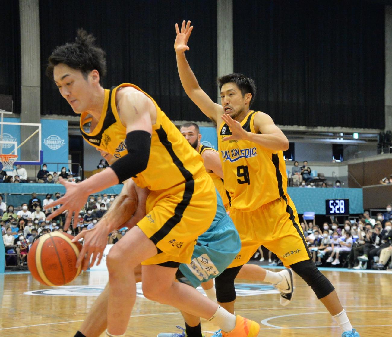第1Q、激しいディフェンスを仕掛ける片岡（右）。手前はゴール下に攻め込む加藤