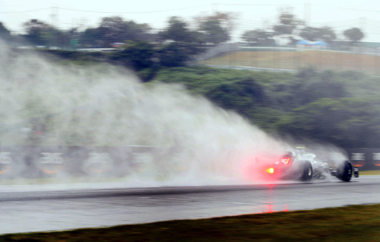 雨のフリー走行1回目、立体交差を抜け、水しぶきを上げるアルファタウリの角田裕毅（撮影・宮崎幸一）