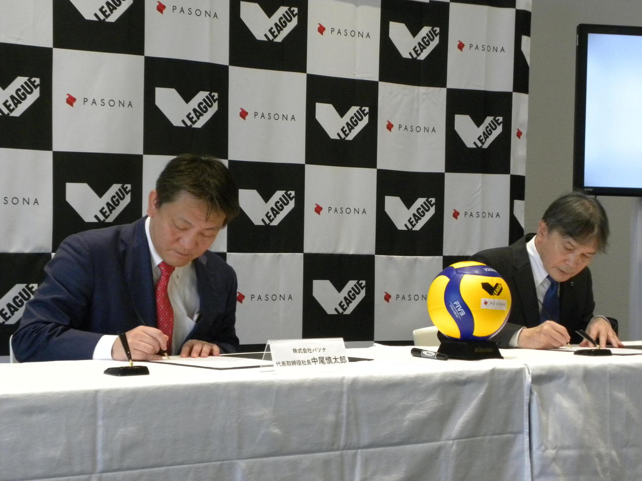 パートナーシップ協定書にサインするVリーグの国分裕之会長（右）とパソナの中尾慎太郎社長（撮影・松本航）