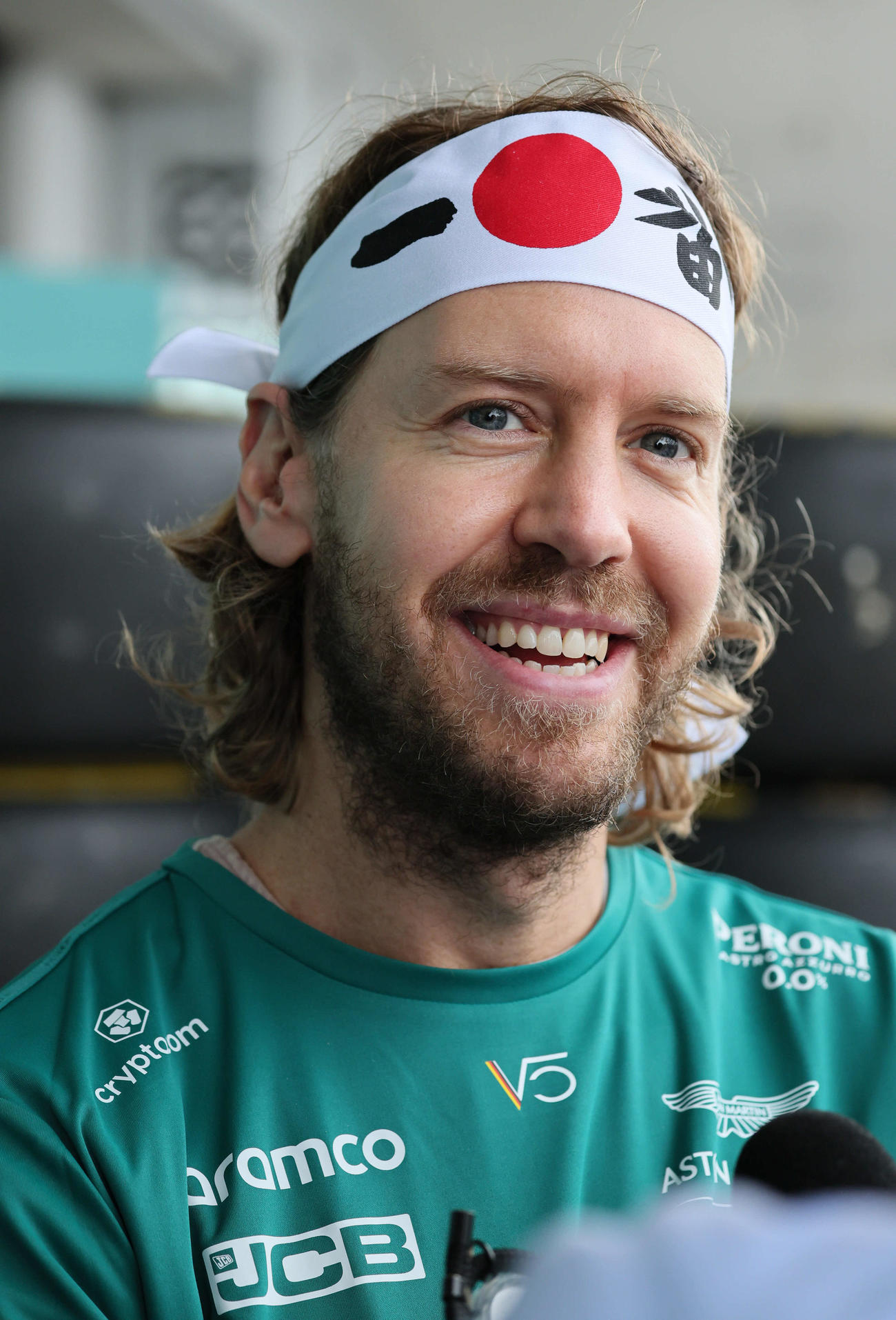 一番と日の丸デザインのハチマキで笑顔を見せるセバスチャン・フェテル（撮影・宮崎幸一）