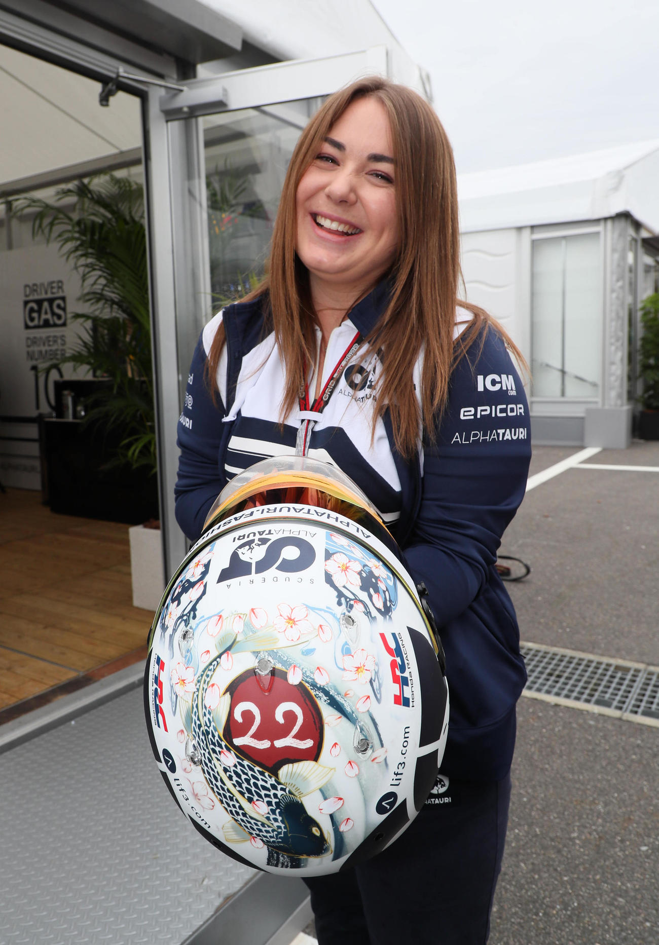 F1を裏から支える女性たち。角田裕毅の日本GPスペシャルペイントのヘルメットを手にするアルファ・タウリのスタッフ（撮影・宮崎幸一）